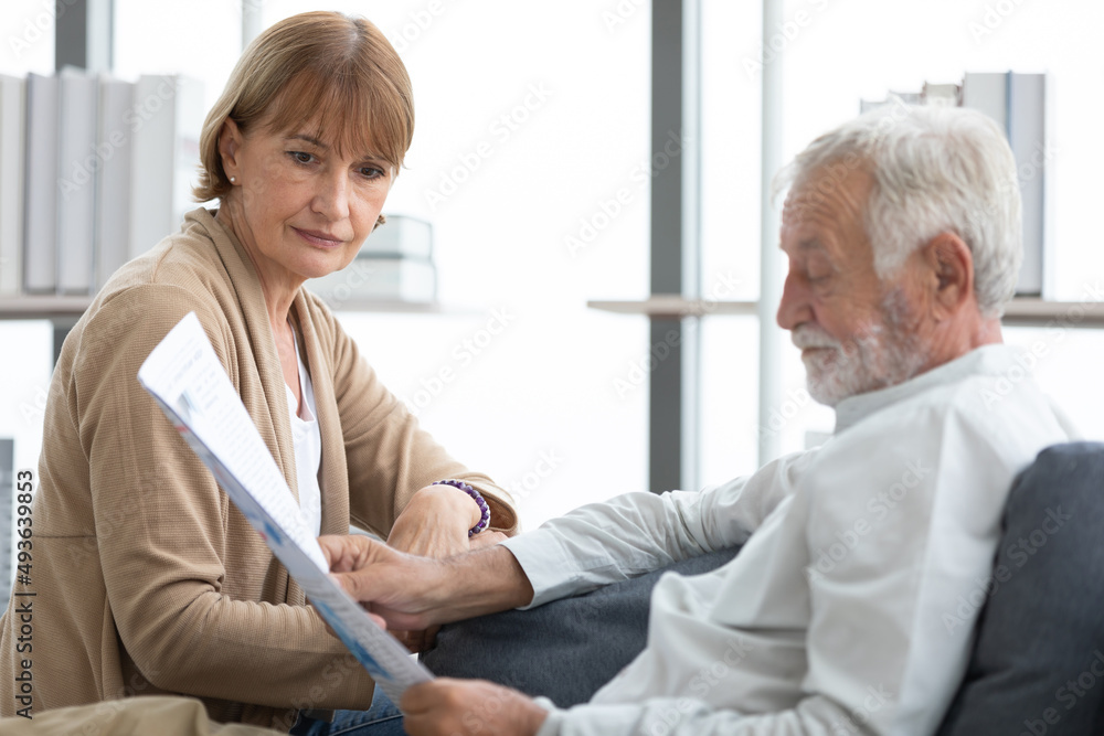 senior couple reading a newspaper in free time senior couple reading a newspaper in free time
