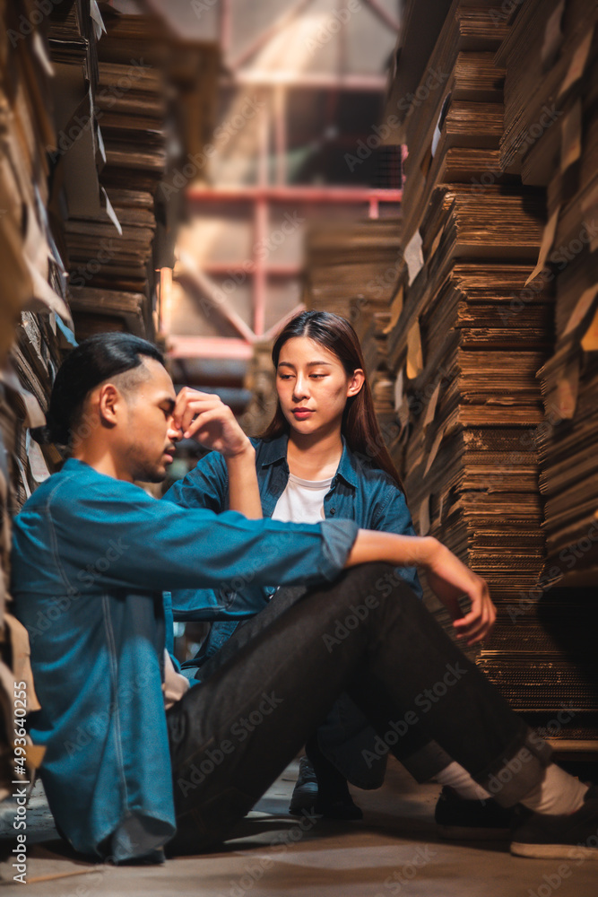Asian Business owner sitting in factory plantation posing feel tried and serious with work.Engineer or Factory worker hard work.Unemployed Feeling Stressed. Asian Business owner sitting in factory plantation posing feel tried and serious with work.Engineer or Factory worker hard work.Unemployed Feeling Stressed.