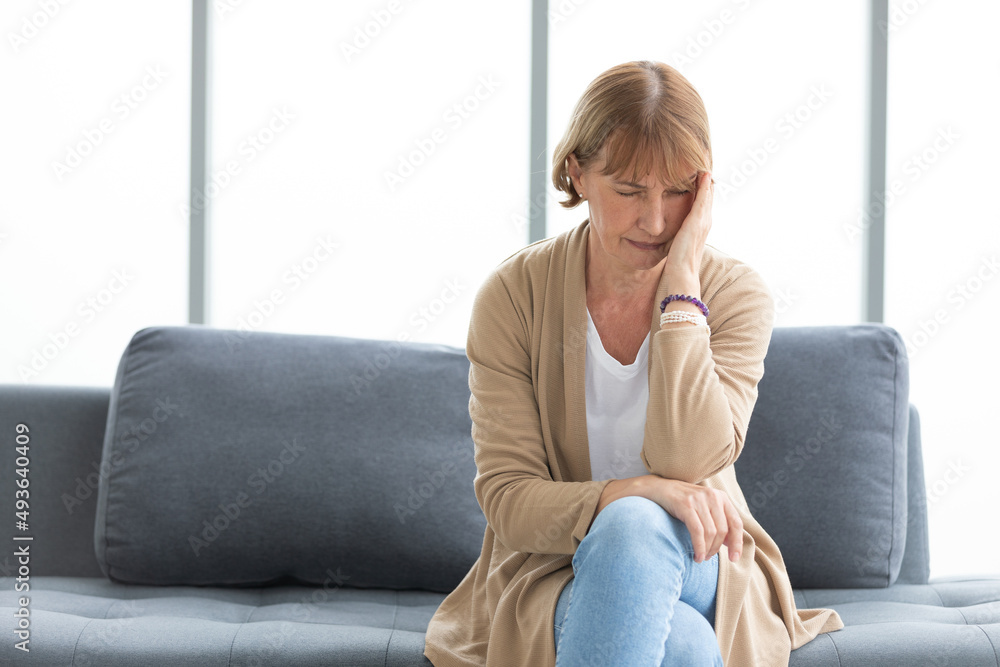 senior woman have a headache on a sofa senior woman have a headache on a sofa