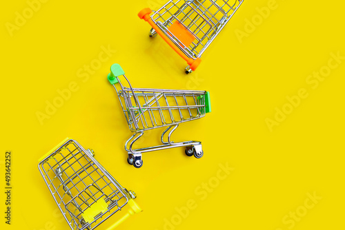 Foto Shopping trolley or Shopping cart on yellow background.