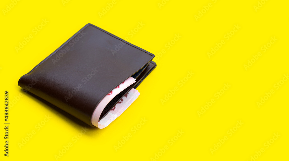 Brown wallet on yellow background Brown wallet on yellow background