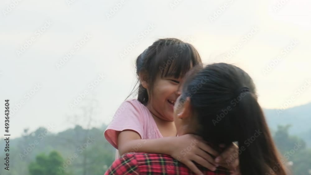 Happy little daughter hugs and kisses her mother in the park. family relationship concept Happy little daughter hugs and kisses her mother in the park. family relationship concept