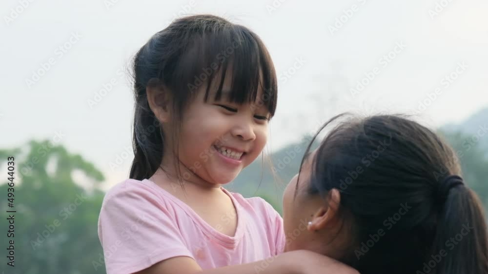 Happy little daughter hugs and kisses her mother in the park. family relationship concept Happy little daughter hugs and kisses her mother in the park. family relationship concept