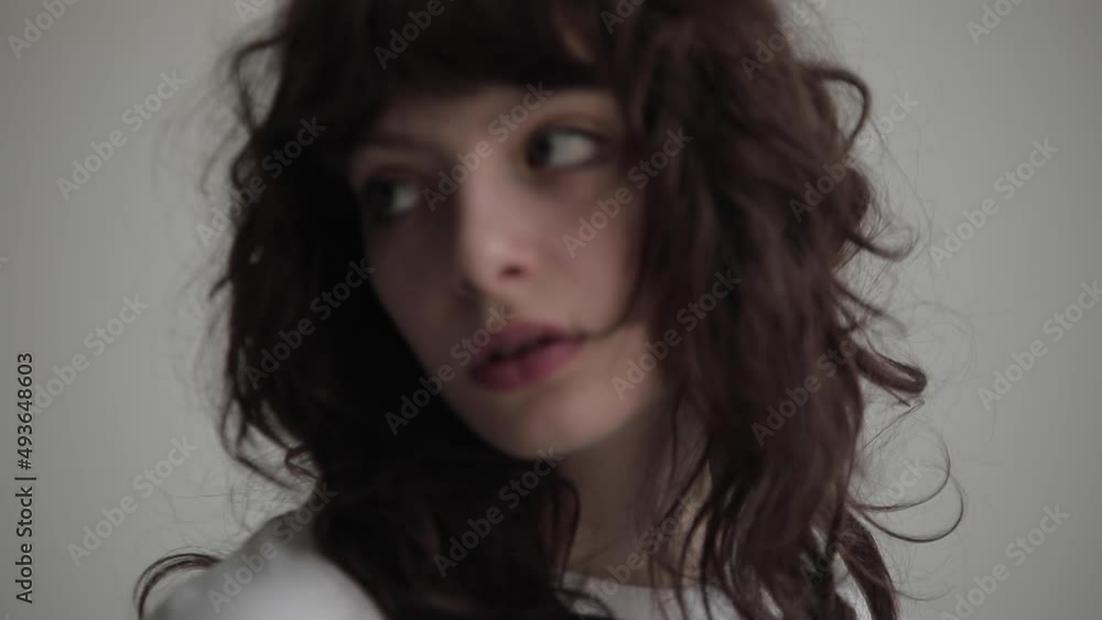 Slow motion portrait of a young woman with curly hair. Slow motion portrait of a young woman with curly hair.