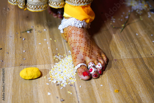 Canvas Print Newly wed Indian bride entering new house a rituals.