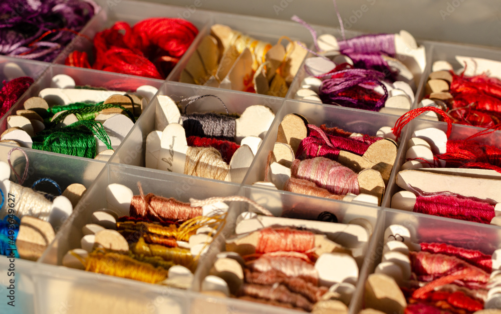 Group of threads of varied colors in small skeins of paper, inside a plastic organizer. Copy space. Technological detox.