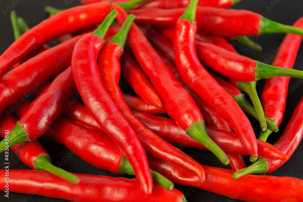 A group of spicy, fresh, red peppers. Hot hili on the black background. Close-Up