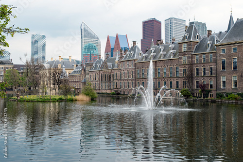 A fountain bursts from a pond that reflects the eclectic architecture that is the skyline of The Hague, Netherlands.