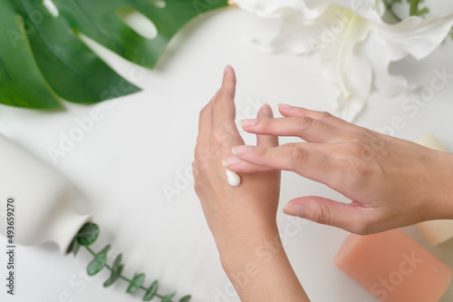 close up hand of applying moisturizing cream  skincare and beauty concept
