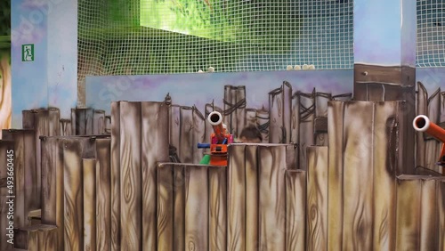a boy shoots soft balls from a toy cannon. children's entertainment center. war game