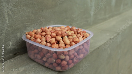 Salted Roasted Peanuts, Peeled raw peanuts are in a plastic cup, Healthy content, Copy space, top view. photo
