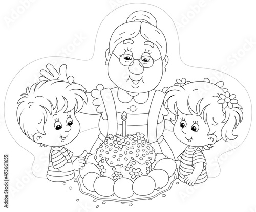 Happy granny and little kids at their festive table with a traditional sweet holiday cake and painted Easter eggs, black and white outline vector cartoon illustration for a coloring book page