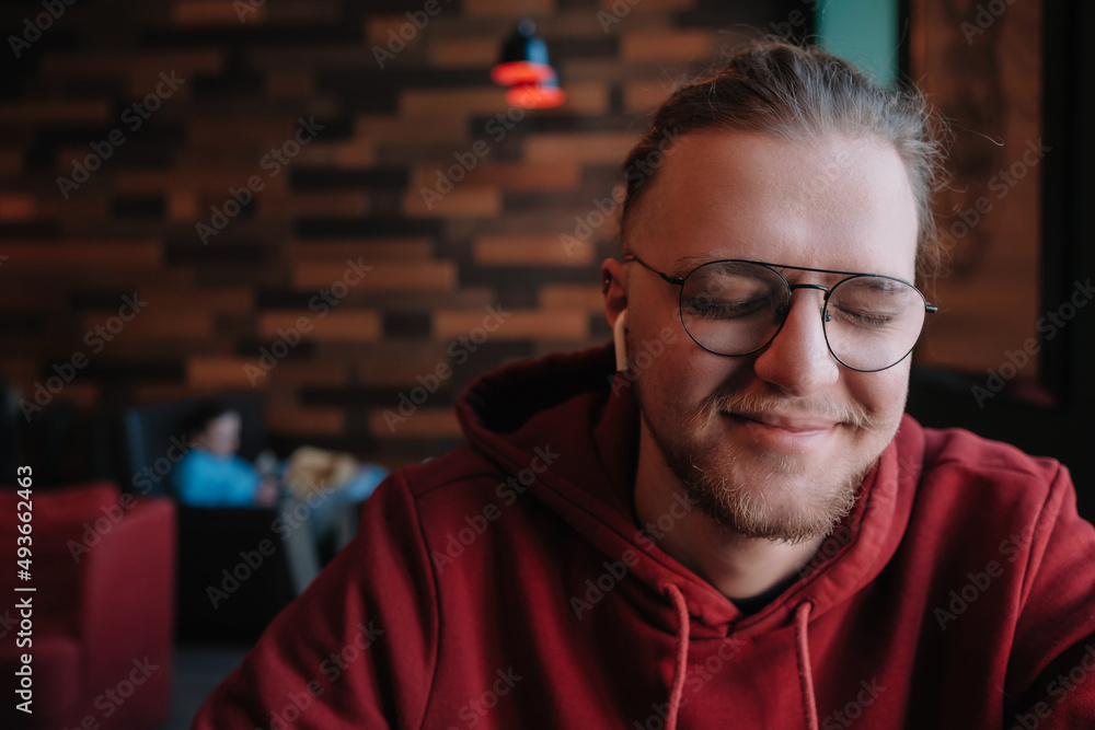Portrait of happy male freelancer in optical eyewear for vision correction smiling at camera during break from web working online, cheerful hipster blogger sitting in cafe with mockup laptop Portrait of happy male freelancer in optical eyewear for vision correction smiling at camera during break from web working online, cheerful hipster blogger sitting in cafe with mockup laptop