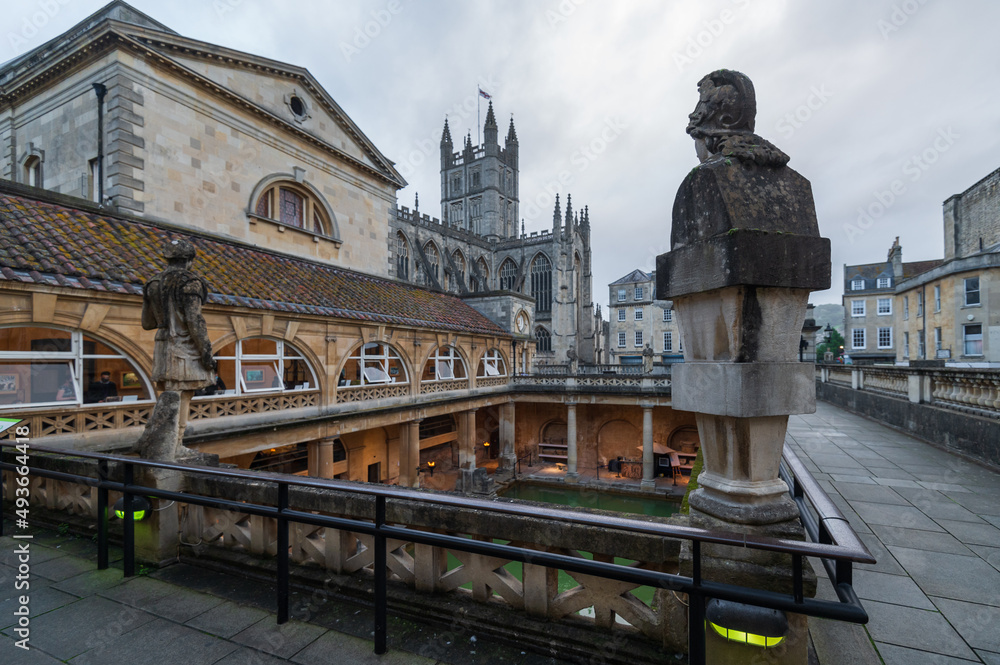 Fototapeta premium City of Bath, UK. Evening sightseeing of restored in Victorian times ancient Roman Baths in the fire light of wall sconces.