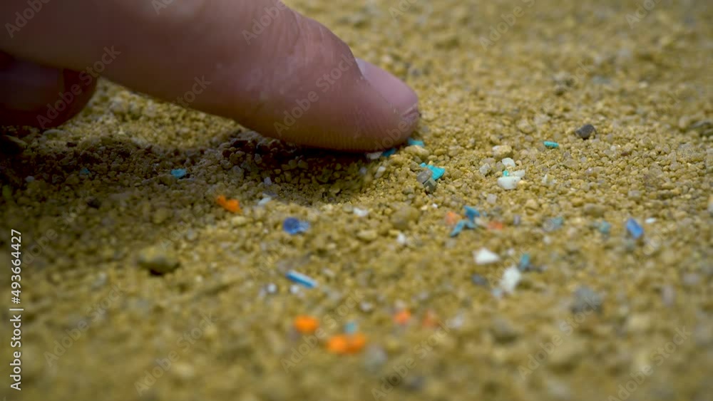 Person examining the micro plastics with his index finger. Person examining the micro plastics with his index finger.
