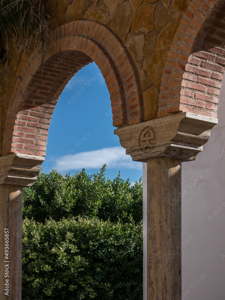 Arabic-style column and arches in the center of Mojacar, Almeria, Andalusia, Spain; showing the traditional Indalo symbol
