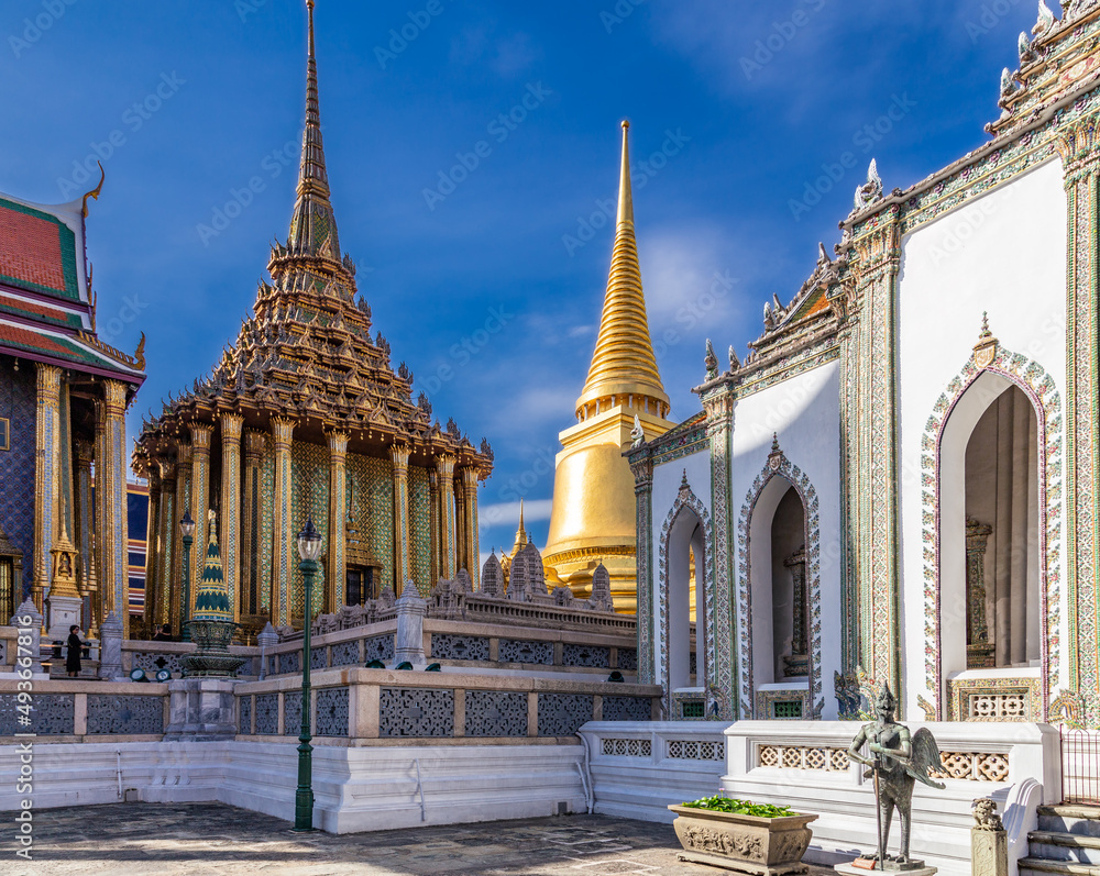 Courtyard of ornate Buddhist temples with golden and colorful decorative details, Bangkok, Thailand