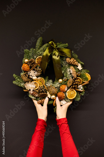 Women's hands hold a New Year's wreath in their hands