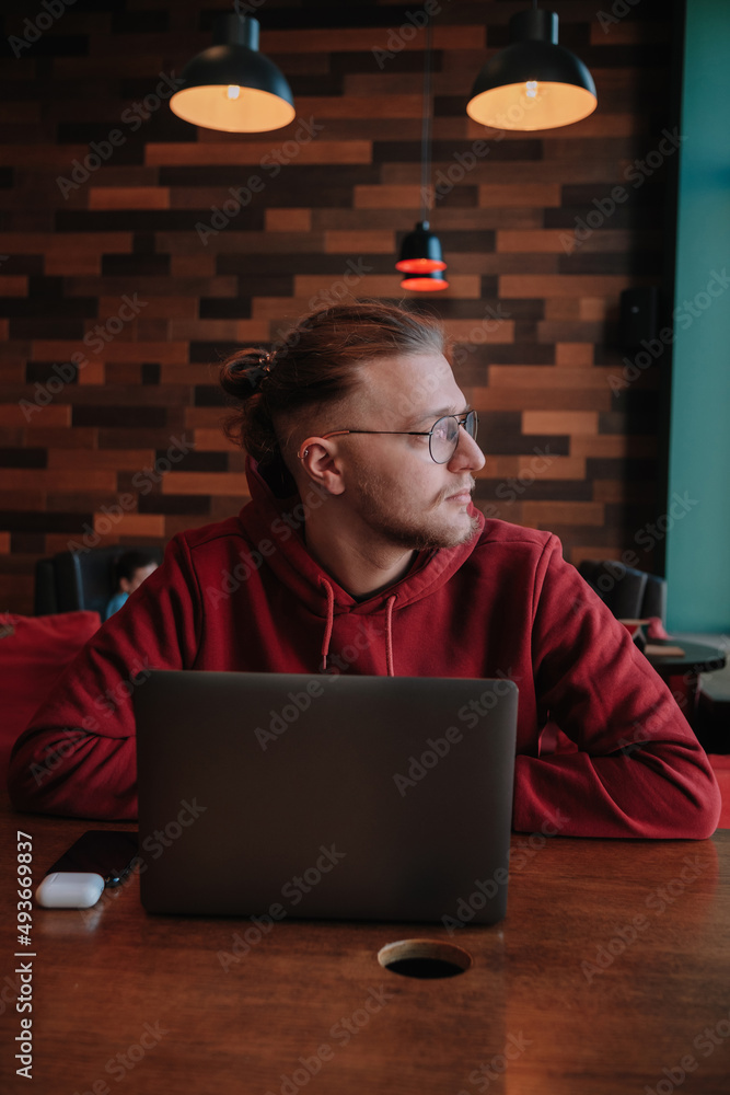 Portrait of happy male freelancer in optical eyewear for vision correction smiling at camera during break from web working online, cheerful hipster blogger sitting in cafe with mockup laptop Portrait of happy male freelancer in optical eyewear for vision correction smiling at camera during break from web working online, cheerful hipster blogger sitting in cafe with mockup laptop