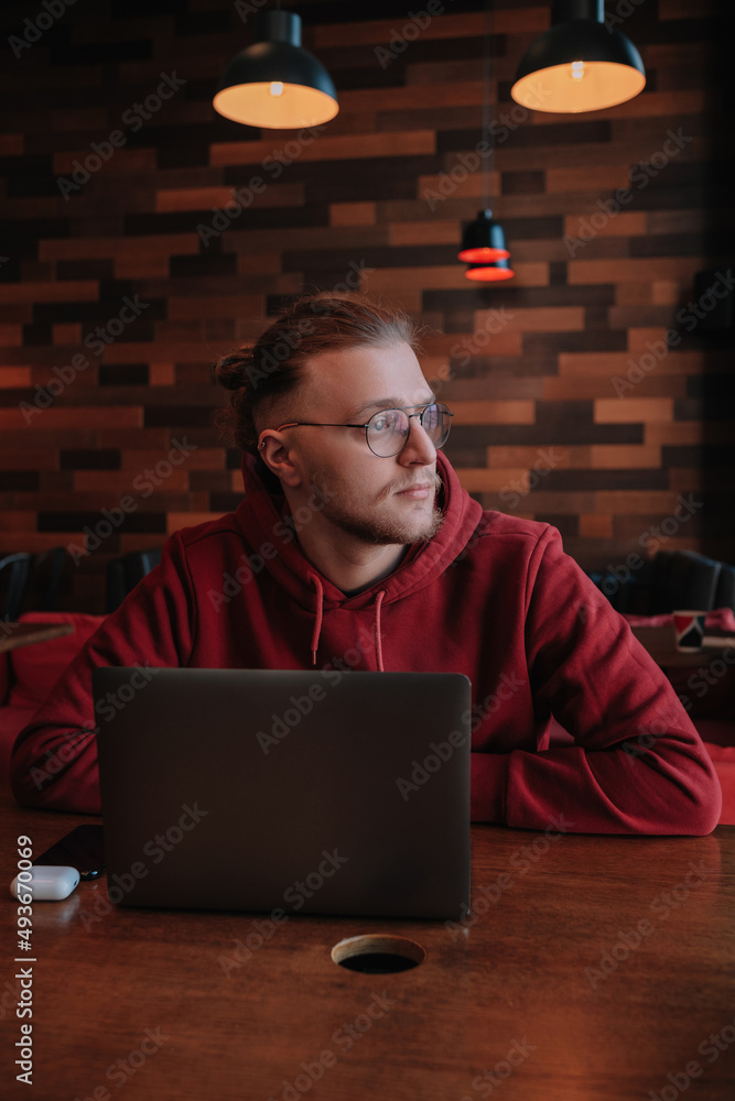Portrait of happy male freelancer in optical eyewear for vision correction smiling at camera during break from web working online, cheerful hipster blogger sitting in cafe with mockup laptop Portrait of happy male freelancer in optical eyewear for vision correction smiling at camera during break from web working online, cheerful hipster blogger sitting in cafe with mockup laptop