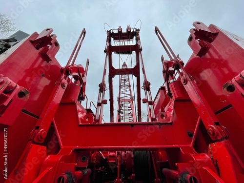 Manitowoc Red Crane Construction scene cloudy rainy day looking up from back