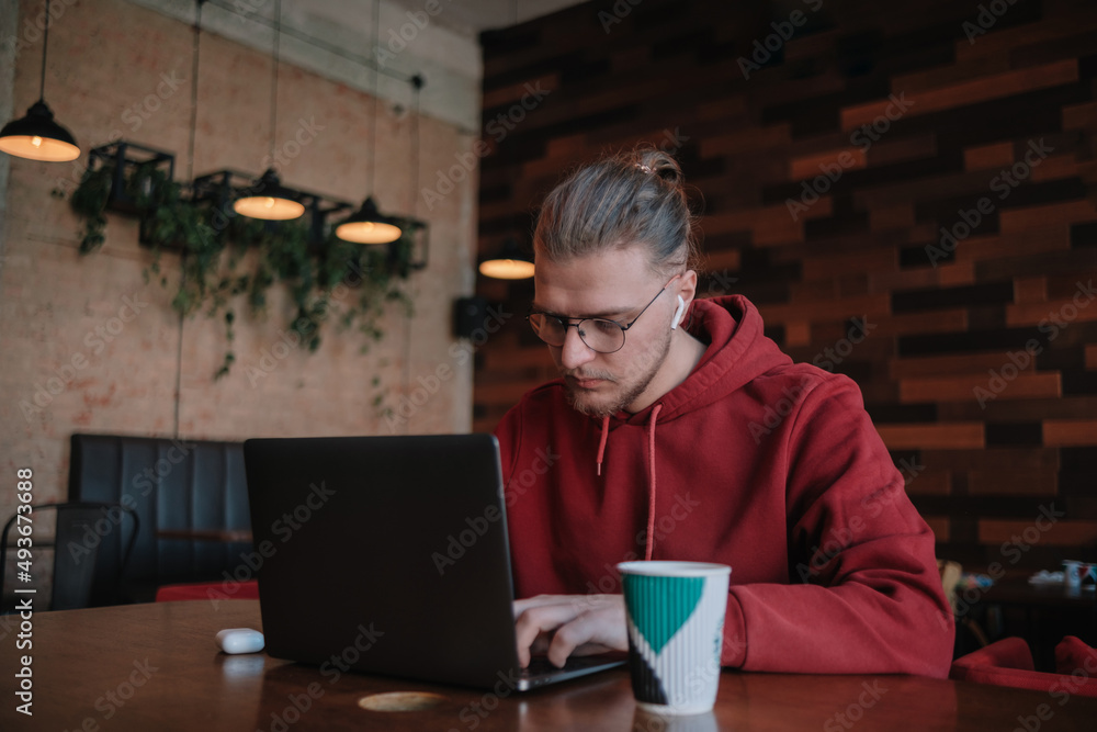Portrait of happy male freelancer in optical eyewear for vision correction smiling at camera during break from web working online, cheerful hipster blogger sitting in cafe with mockup laptop Portrait of happy male freelancer in optical eyewear for vision correction smiling at camera during break from web working online, cheerful hipster blogger sitting in cafe with mockup laptop