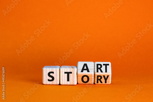 Start your story symbol. Turned wooden cubes and changed the concept word Start to Story. Beautiful orange table orange background, copy space. Business start your story concept.