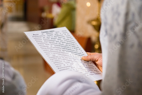 person reading a page from a bible praying into the church 