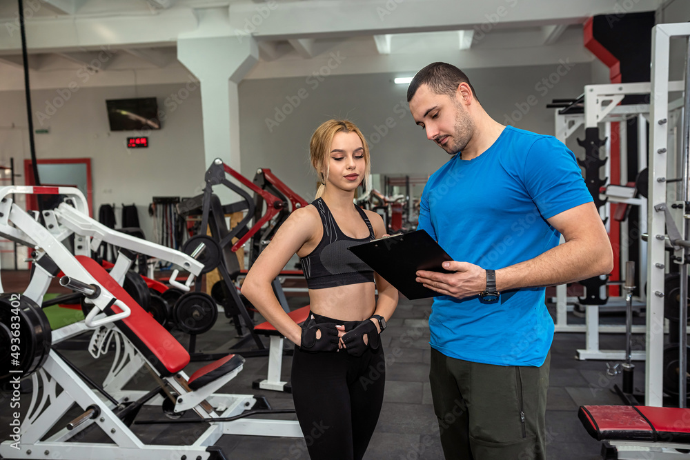 Fitness male trainer with his woman client working exercising at the gym Fitness male trainer with his woman client working exercising at the gym