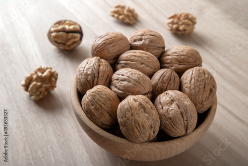 Walnut kernels and whole walnuts on wooden background,front view 