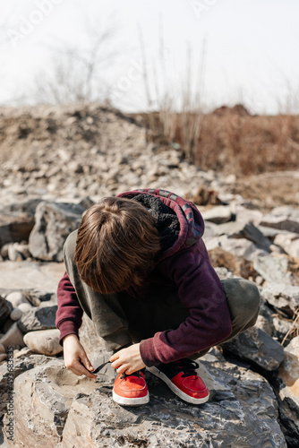 little child playing
on the banks of a mountain river