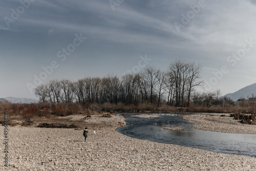 
girl with a dog walking on a background of mountains
nature
river with snow
