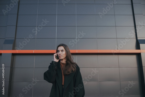 brunette cute girl talking by the phone