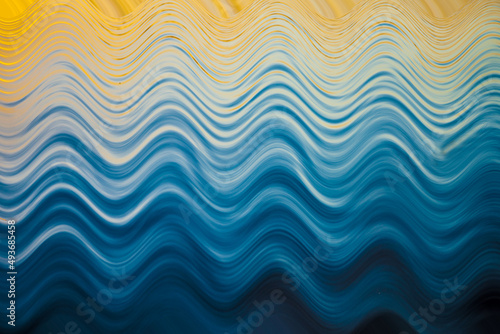 Abstract wavy pattern on water surface in blues and yellow