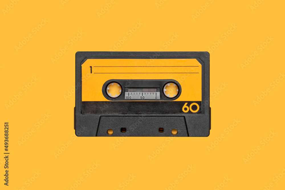 Fototapeta premium VINTAGE CASSETTE AUDIO TAPE LOOP ISOLATED ON ORANGE BACKGROUND.