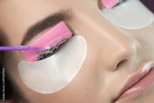 Master applies care perm cream to eyelashes. Close-up of beauty model's face during lash lift laminating botox procedure. Eyelash Care Treatment: eyelash lifting and curling, lash lamination 