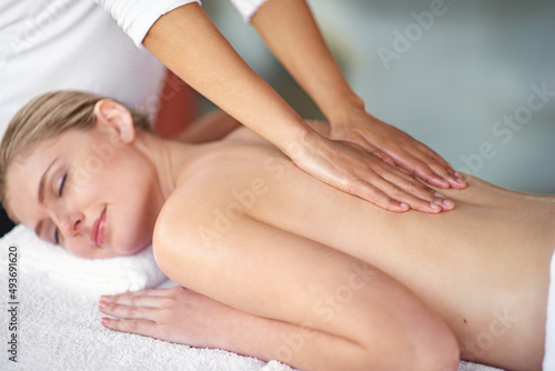Let all your tension melt away.... Shot of a young woman enjoying a massage at the spa.