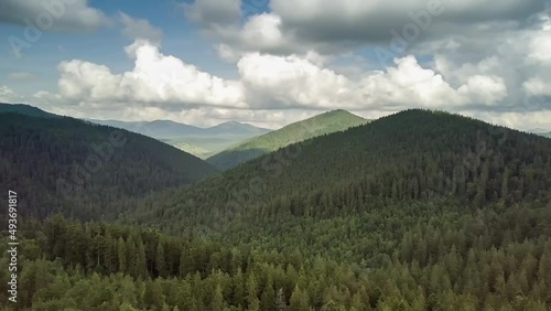 Mountain peaks and morning sky with smooth moving clouds. Summer landscape paeceful valley trees in the meadow at Carpathian mountains. Ukraine. photo