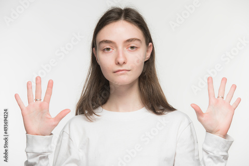 Wallpaper Mural close-up portrait of a young Ukrainian girl who shows the number with her hands on a white background
 Torontodigital.ca