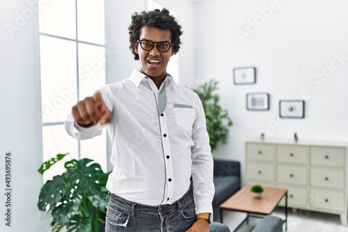 African psychologist man at consultation office pointing displeased and frustrated to the camera, angry and furious with you