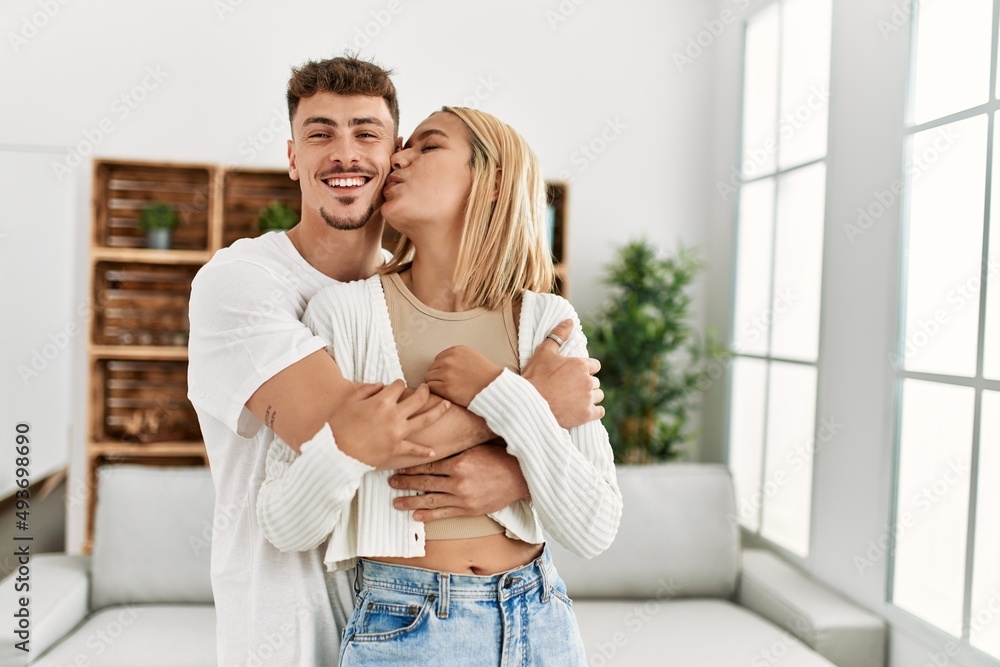 Young caucasian couple smiling happy hugging and kissing at home. Young caucasian couple smiling happy hugging and kissing at home.