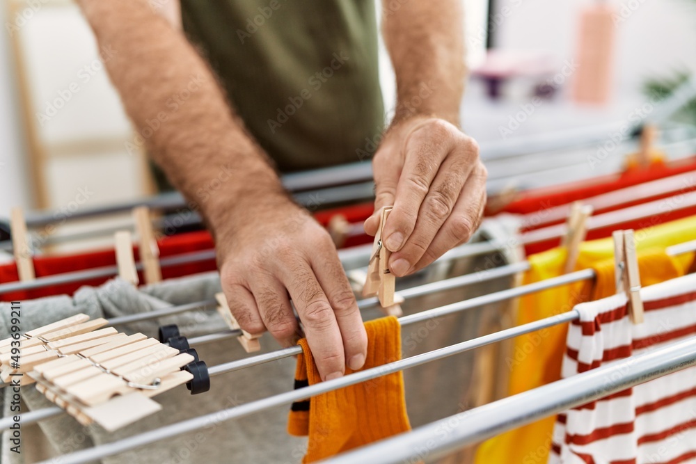 Middle age hispanic man hanging clothes at clothesline at laundry room Middle age hispanic man hanging clothes at clothesline at laundry room