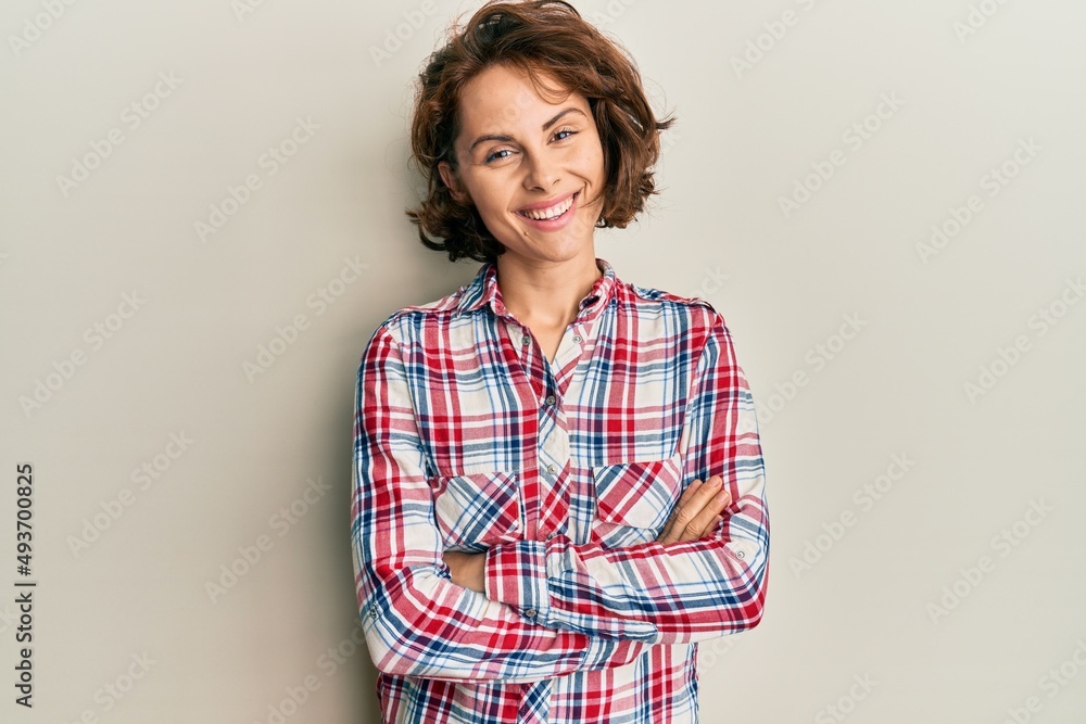 Young brunette woman wearing casual clothes happy face smiling with crossed arms looking at the camera. positive person. Young brunette woman wearing casual clothes happy face smiling with crossed arms looking at the camera. positive person.
