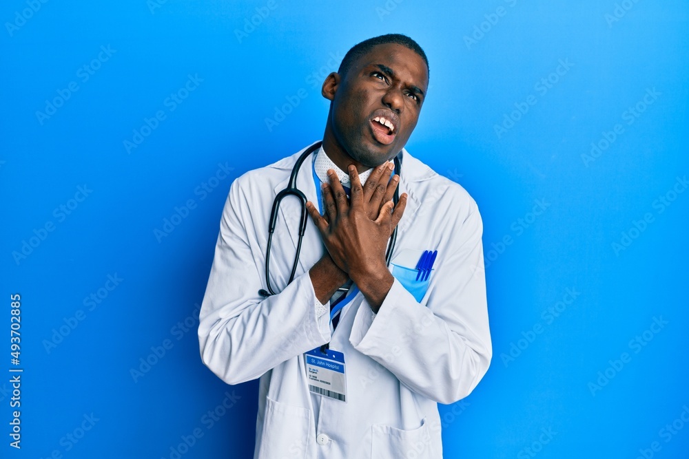 Young african american man wearing doctor uniform shouting and suffocate because painful strangle. health problem. asphyxiate and suicide concept. Young african american man wearing doctor uniform shouting and suffocate because painful strangle. health problem. asphyxiate and suicide concept.