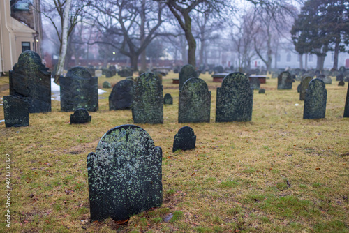 Blank weathered tombstone at historic graveyard in early morning mist photo