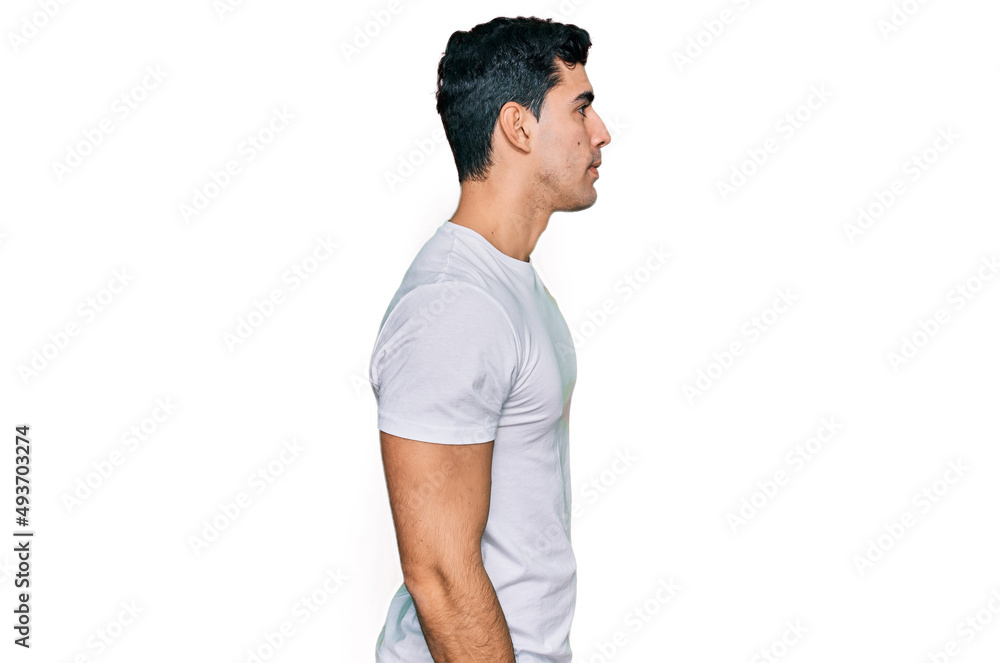 Handsome hispanic man wearing casual white t shirt looking to side, relax profile pose with natural face with confident smile. Handsome hispanic man wearing casual white t shirt looking to side, relax profile pose with natural face with confident smile.