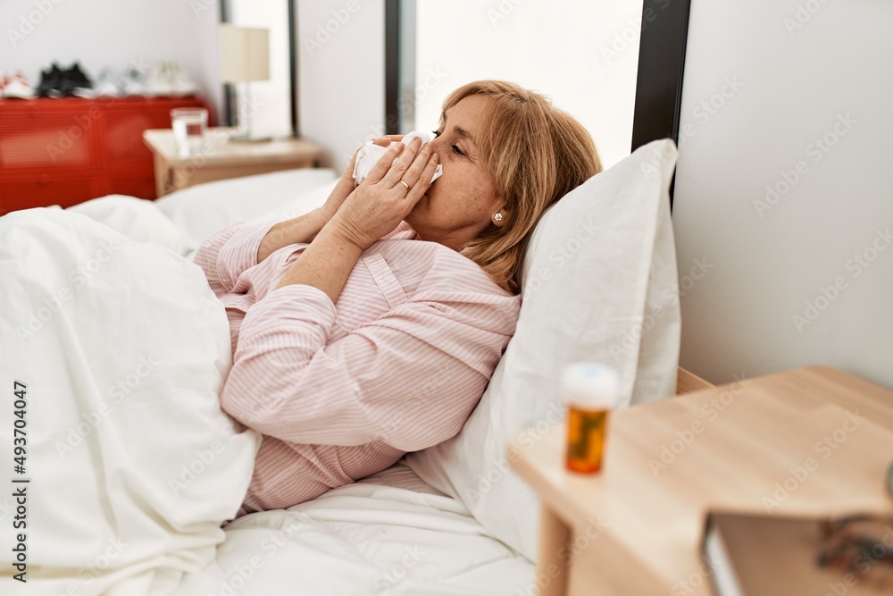 Middle age blonde woman smiling happy lying on the bed at home. Middle age blonde woman smiling happy lying on the bed at home.