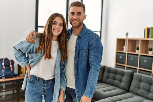 Young caucasian couple smiling happy standing at home.