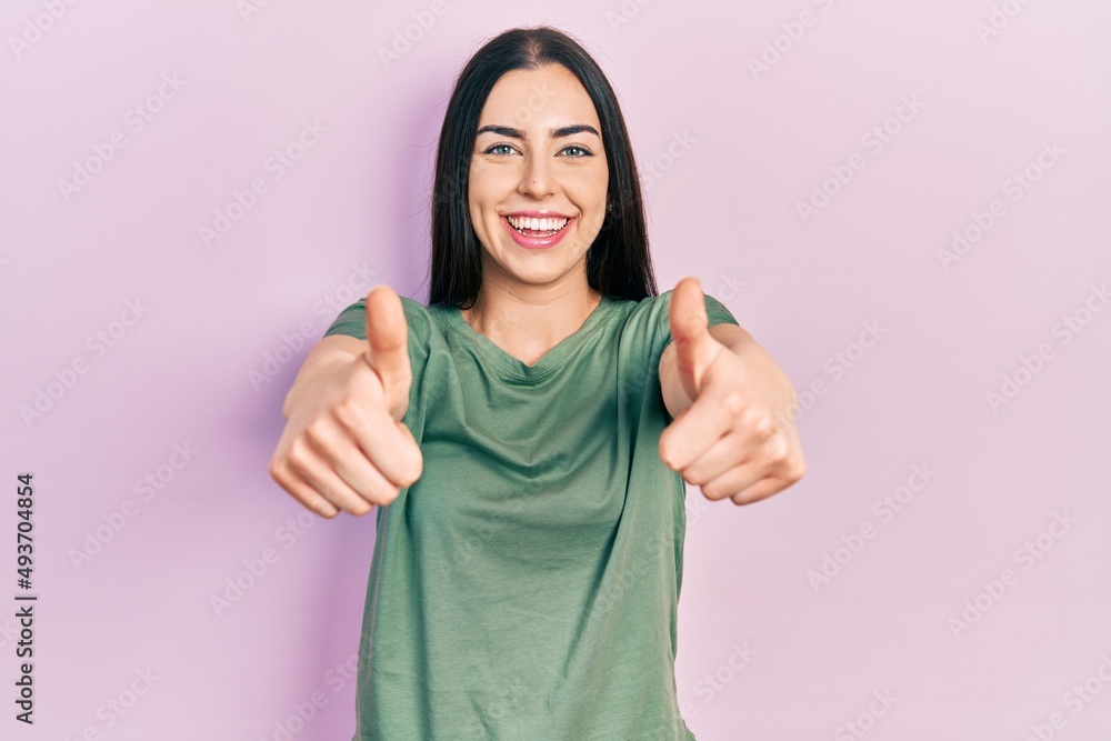 Beautiful woman with blue eyes wearing casual t shirt approving doing positive gesture with hand, thumbs up smiling and happy for success. winner gesture. Beautiful woman with blue eyes wearing casual t shirt approving doing positive gesture with hand, thumbs up smiling and happy for success. winner gesture.