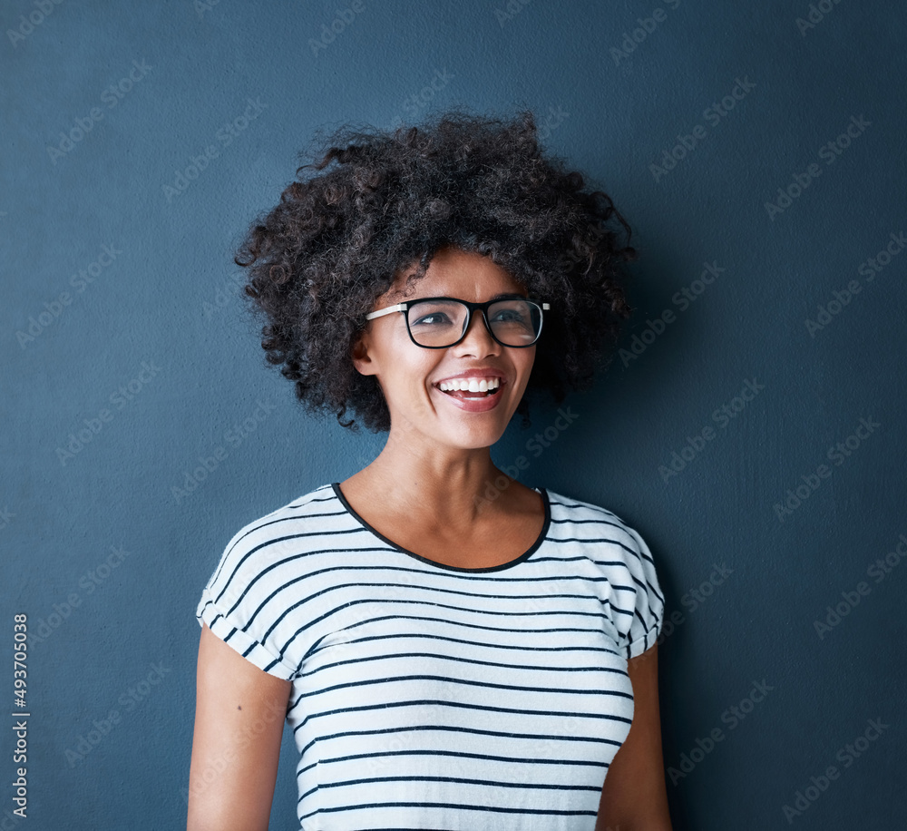 Seeing the good side of life. Studio shot of an attractive and happy young woman wearing glasses against a blue background. Seeing the good side of life. Studio shot of an attractive and happy young woman wearing glasses against a blue background.